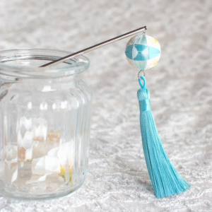 This light blue hairpin features a delicate temari ball and swaying tassels.